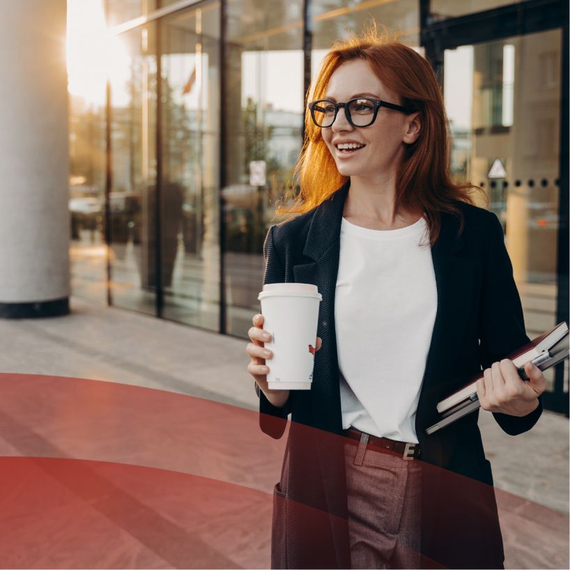 woman outside holding coffee and smiling