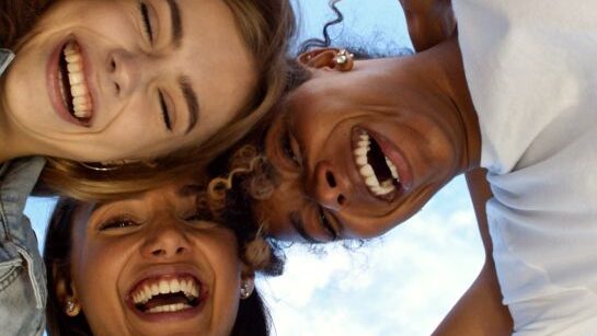 group of friends smiling and huddled over the camera