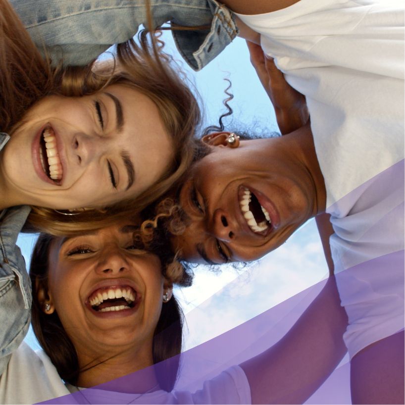 group of friends smiling and huddled over the camera