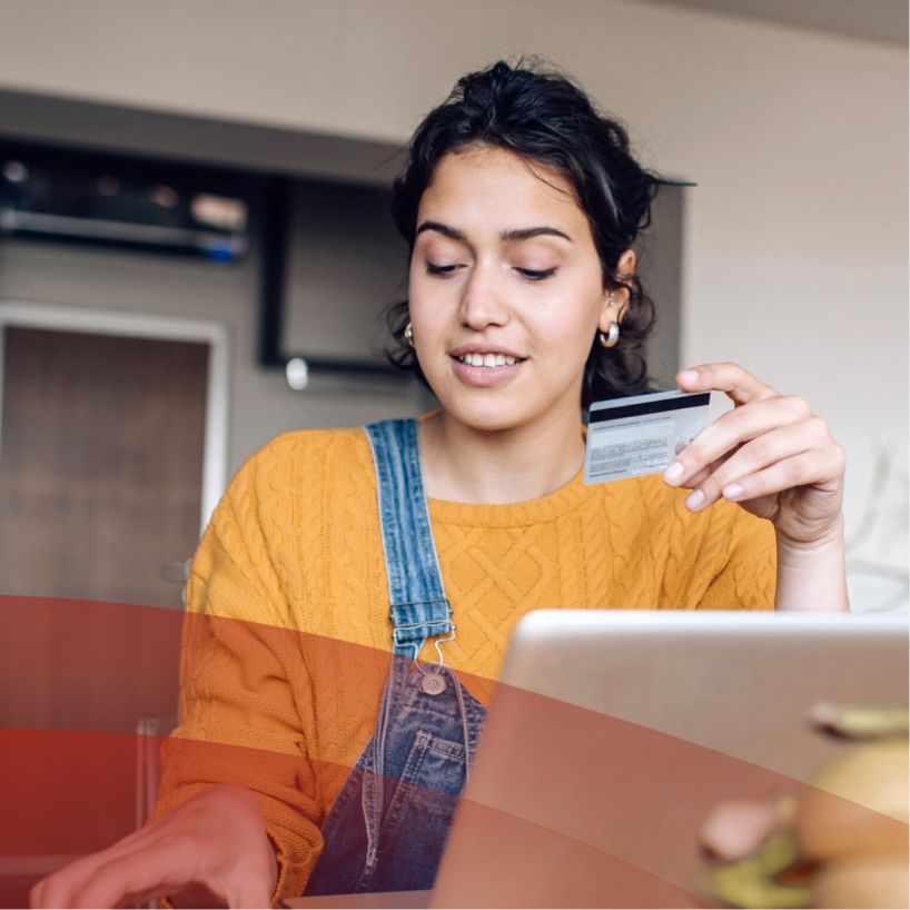 woman looks at her credit card while online