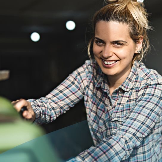 Small business owner smiling while cleaning shop
