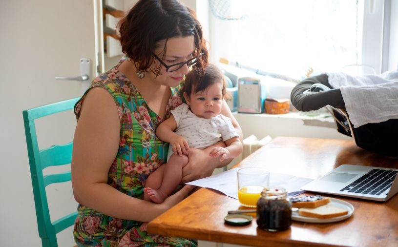 woman taking online course with infant in her lap