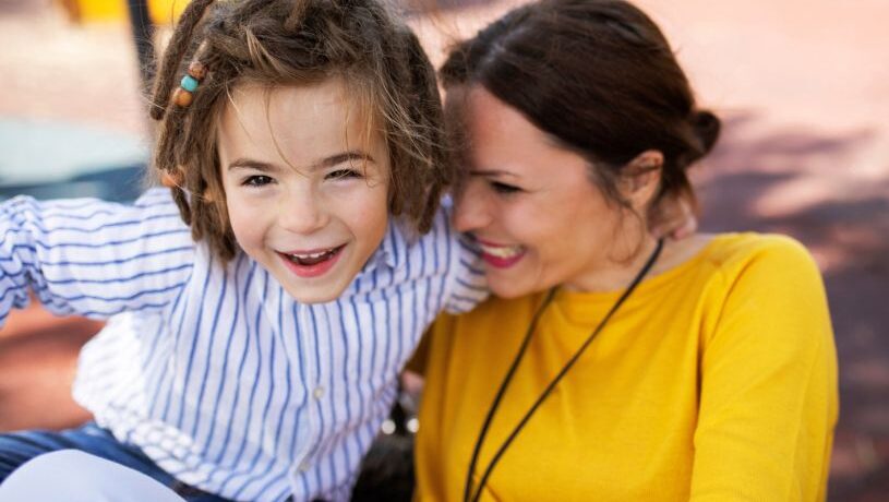 Woman and child smiling at the park