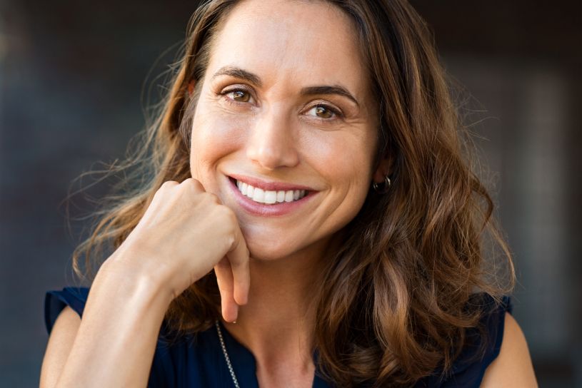 Happy woman with hand on chin