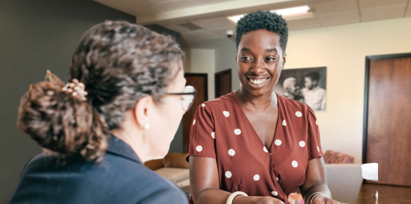 woman smiling in front of fresh start women meeting and smiling at resource center